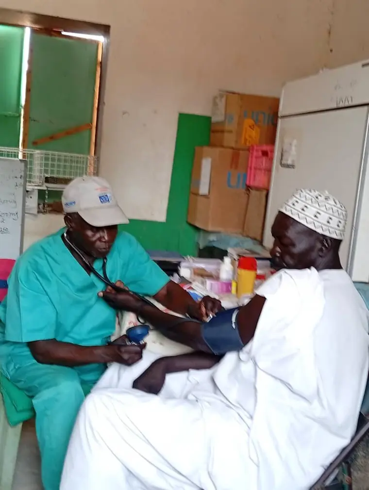 A clinician taking a patient's blood pressure during outpatient clinic